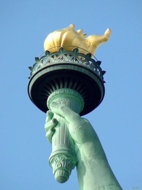 what does the torch held by the statue of liberty symbolize